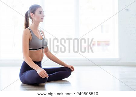 Photo Of A Young, Beautiful Woman, Doing Yoga And The Lotus Posity In The Studio, Beautiful And Heal