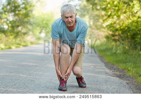 Attractive Grey Haired Elderly Male Pulled Muscle Of Leg, Suffers From Pain, Can`t Continue Jogging,