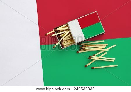 Madagascar Flag  Is Shown On An Open Matchbox, From Which Several Matches Fall And Lies On A Large F