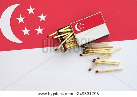 Singapore Flag  Is Shown On An Open Matchbox, From Which Several Matches Fall And Lies On A Large Fl