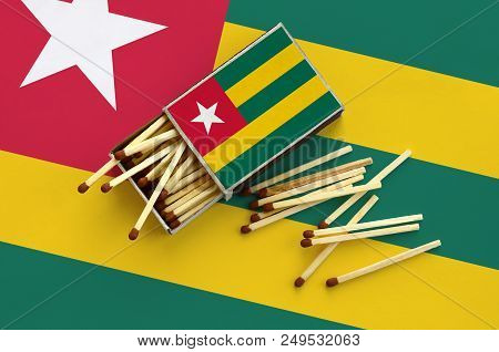 Togo Flag  Is Shown On An Open Matchbox, From Which Several Matches Fall And Lies On A Large Flag.