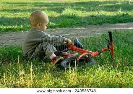 A Little Boy Dreams Of Becoming A Mechanic. The Guy Trains On A Bicycle. The Child Spins The Nuts On