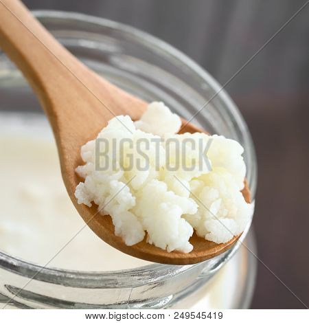Milk Kefir Grains On Wooden Spoon On Top Of A Jar Of Kefir, Photographed With Natural Light (selecti