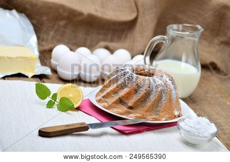 Homemade Lemon Marble Cake Sprinkled With Sugar, Milk, Eggs, Melissa Leaves, And Butter, Still Life 