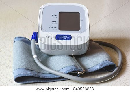 White Electronic Tonometer Close-up On A Wooden Table. Measurement Of Blood Pressure. Healthy Concep
