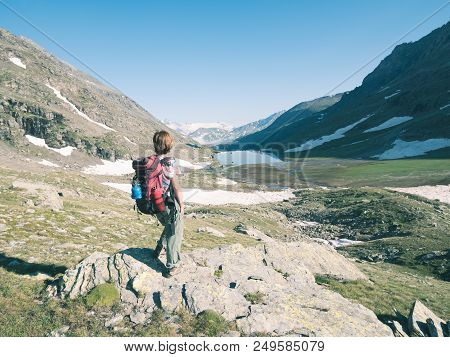 One Person Backpacker Looking At View High Up On The Alps. Expasive Landscape, Idyllic View At Sunse