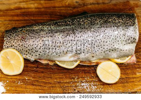 Raw Fish. Raw Fresh Salmon, Trout, On A Table On A Cutting Board. Kitchen. With Lemon Ready For Baki