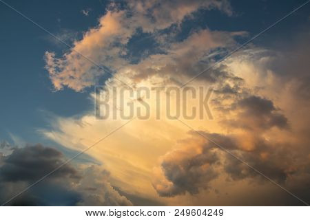 Majestic Clouds Illuminated By Sunset Light. Gloomy Rainy Sky With A Bright Cloud. Abstract Backgrou