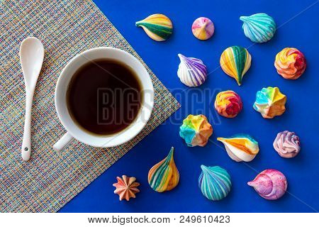 Still Life With A Cup Of Tea And A Scattering Of Colorful Meringue Cakes. Appetizing Meringues. Back