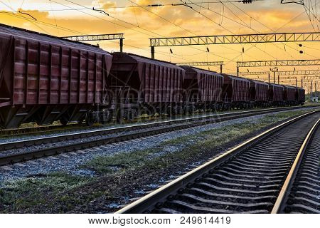 railcar for dry cargo during beautiful sunset and colorful sky, railroad infrastructure, transportation and industrial concept