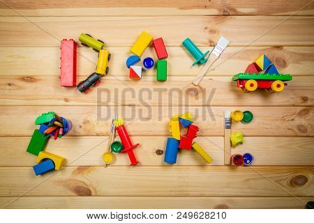 Day Care Concept - Letters Made Of Toys And Art Supply, Top View, Copy Space