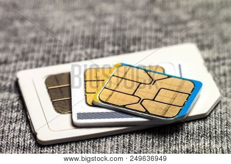 Set Of Mini, Micro And Nano Simcard. Isolated On Grey Cloth Texture Background