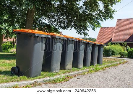 Row Of Gray Waste Containers For Packaging Material Along The Street