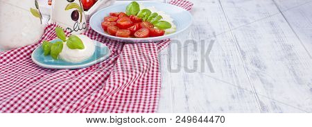 Traditional Italian Salad With Fresh Cherry Tomatoes And Soft Mazarella Cheese, With Basil And Olive