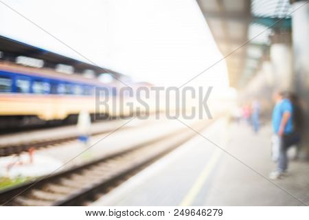 Blurred Image With Passengers Waiting Train On Platfom At Railway Station. Tourists With Baggage.