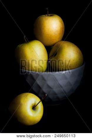 Bowl Of Yellow Apples. On Black Background.
