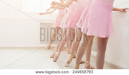 Ballet Background, Young Ballerinas Training. Female Dancers Legs In Pointe Shoes, Making Exercises.