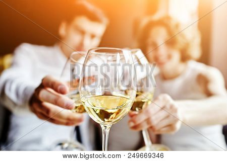 Leisure, Celebration, Drinks, People And Holidays Concept - Happy Couple And Friend Clinking Glasses