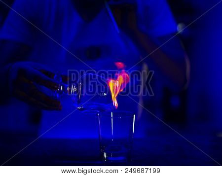 Bartender Burning Sambuca At The Bar Blue Background