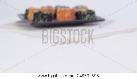 Different Types Of Maki Sushi On A Black Plate.isolated On White Background