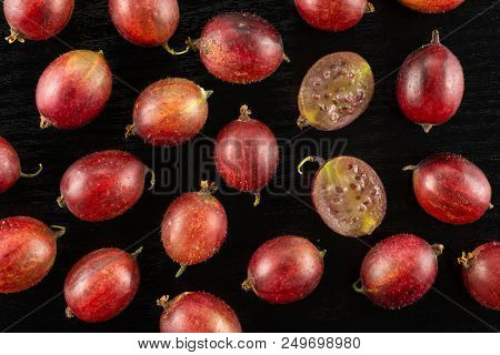 Lot Of Whole Fresh Red Gooseberry Hinnomaki Variety Flatlay On Black Wood