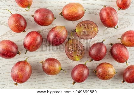 Lot Of Whole Fresh Red Gooseberry Hinnomaki Variety Flatlay On Grey Wood