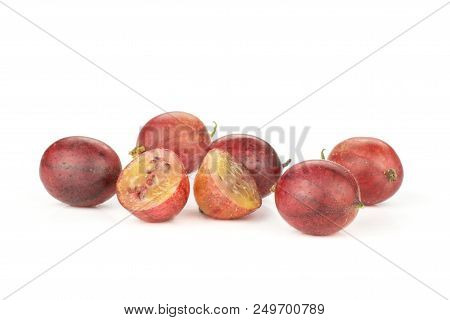 Group Of Five Whole Two Halves Of Fresh Red Gooseberry Hinnomaki Variety Isolated On White