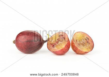 Group Of One Whole Two Halves Of Fresh Red Gooseberry Hinnomaki Variety Isolated On White