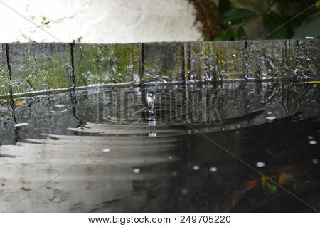 Raindrop Hitting Water Surface On Full Water Barrel