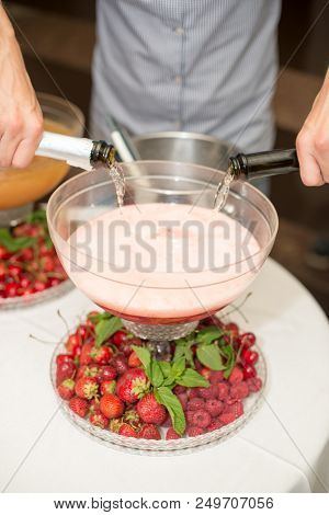 Beverage With Ice Cubes. Pouring Champagne. Mint And Fruit Are Out Of Focus