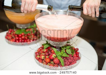 Beverage With Ice Cubes. Pouring Champagne. Mint And Fruit Are Out Of Focus