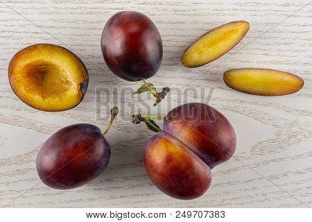 Group Of Three Whole One Half Two Slices Of Fresh Violet-blue Plum Vibrant Moyer Variety Flatlay On 