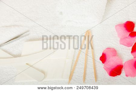 Manicurist Set, Cuticles Wooden Sticks Pusher And White Files On Towel With Rose Petals.