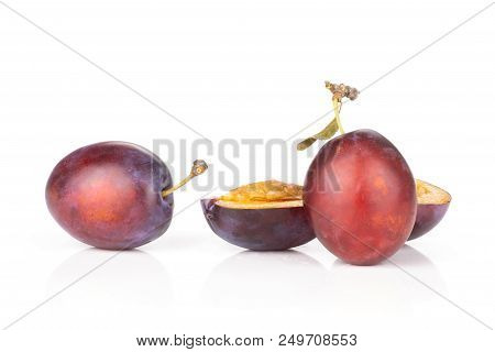Group Of Two Whole Two Halves Of Fresh Violet-blue Plum Vibrant Moyer Variety Isolated On White