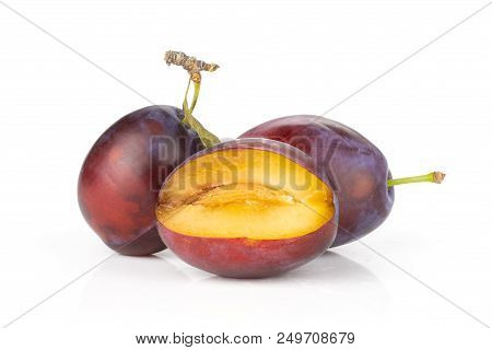 Group Of Two Whole One Half Of Fresh Violet-blue Plum Vibrant Moyer Variety Isolated On White