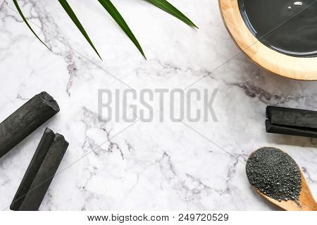 Facial Mask And Scrub By Activated Charcoal Powder On Marble Table. Free Space For Text
