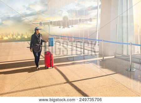 Woman With Traveling Luggage Walking In Airport Teminal And Air Plane Flying Background