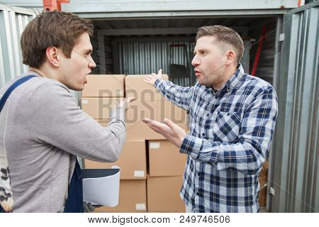 Emotional storage worker and container owner disputing and gesturing while arguing about content of container outdoors