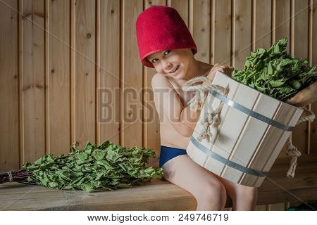 Portrait Of A Little Boy Of 5 Years Wrapped In A Towel At Preschool Age, Sitting In A Sauna And Havi