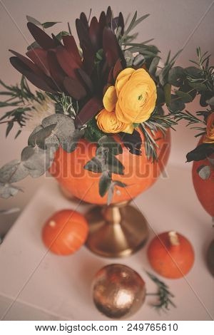 Beautiful Autumn Floral Bouquet In A Pumpkin Vase. Preparing For Halloween. Table Setting For The We