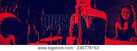 Mid section of female singer performing with team in nightclub