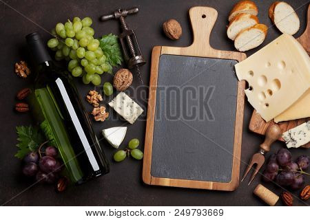 Wine, cheese, grape, bread and nuts. Top view with space for your text