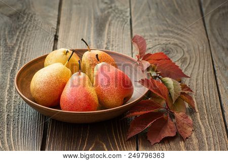Pears. Collecting Pears. Fresh Ripe Pears In A Clay Plate With Autumn Leaves On A Wooden Table. Pear