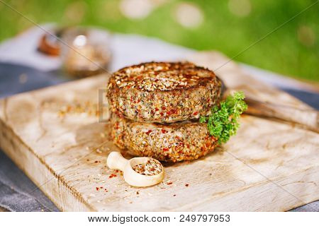 lamb burgers spiced by mint and lamb rub on wooded board