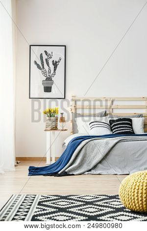 Black And White Cactus Poster Hanging On The Wall In Bright Bedroom Interior With Yellow Fresh Flowe