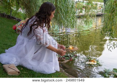 Kiev, Ukraine - July 06, 2018: Girl Launches A Wreath Performing A Slavic Ritual Of Fortune Telling 