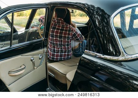 Couple, Man And Woman Are Sitting In The Car, The Guy Is Hugging The Girl. Traveling Together. Check