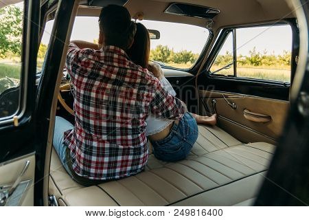 Couple, Man And Woman Are Sitting In The Car, The Guy Is Hugging The Girl. Traveling Together. Check
