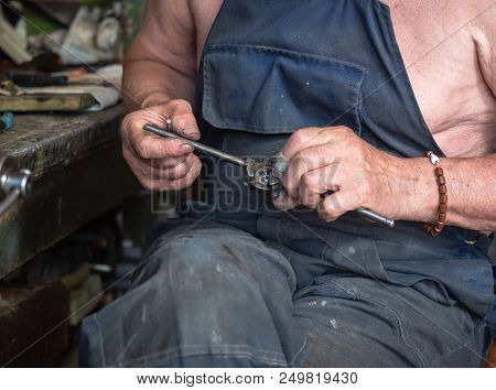 Close Up On Man's Hands With Threading Die. Blurred Background, Soft Selective Focus. The Man Is Dec