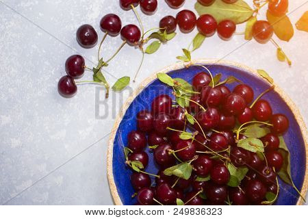Top View Of Cherries In A Plate And On A Table To Make Compote Or Fresh Juice